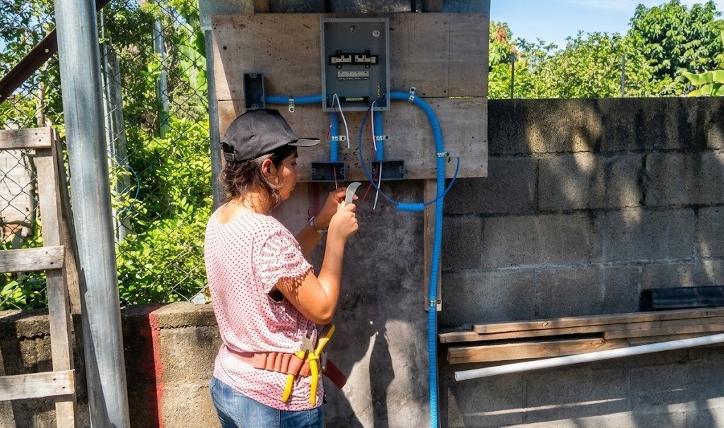 Becaria trabajando en instalación eléctrica
